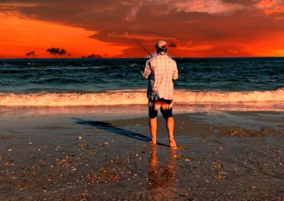 Chris Plaford - reeling in fish under an orange sky